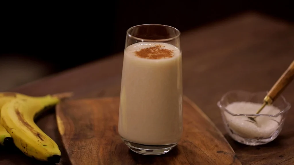 Easy Indian Picnic Menu Ideas: Recipes That Travel Well 15 A tall glass filled with fresh banana milkshake, garnished with cinnamon