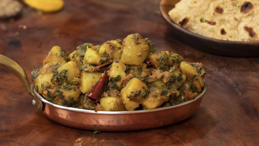 8 Irresistible Potato Dishes for Every Mood – From Breakfast to Dinner 7 Aloo palak sabji served in a bowl beside chapati